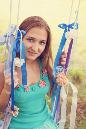 Beautiful young woman on a swing, tintedの写真素材