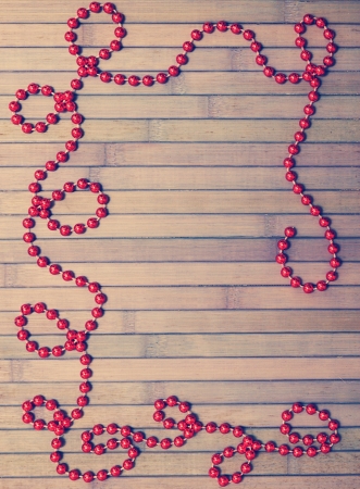 Red Christmas garland on old wooden boardsの写真素材