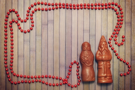 two statuettes chocolate Santa Claus on a wooden backgroundの写真素材