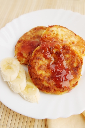 Roasted pancakes with raspberry jam and a bananaの写真素材