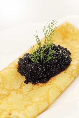 Ruddy pancake with black caviar and dillの写真素材