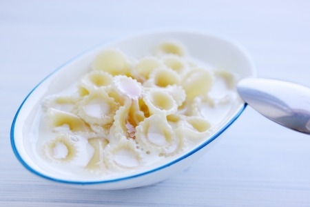 sweet macaroni with milk on a painted boardの写真素材
