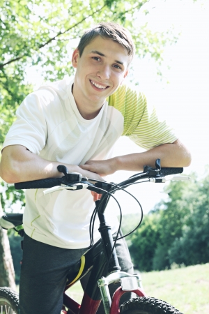 Portrait of a friendly young guy on a bikeの写真素材