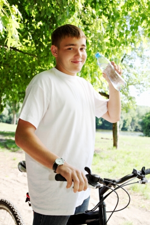 Young boy on a bike drinking waterの写真素材