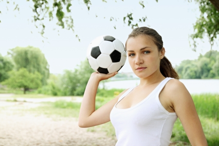 Beautiful woman with a ball in her hands at the beachの写真素材