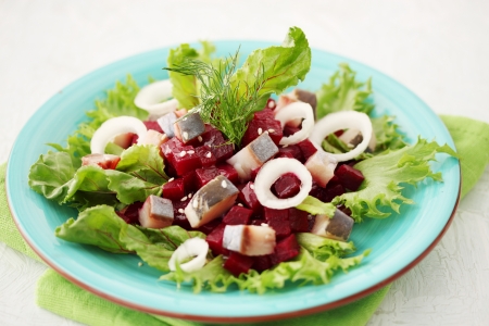 Herring salad, beets, beet leaves and sesame seedsの写真素材
