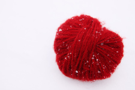 heart of red woolen threads in the snowの写真素材