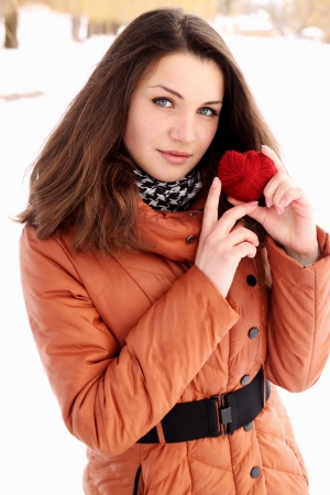 Young woman holding a red heart in the hands ofの写真素材