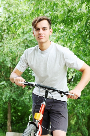 Portrait of a friendly young guy on a bikeの写真素材