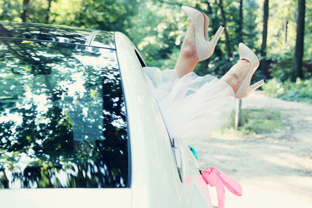 Bride put legs in car window, tintedの写真素材