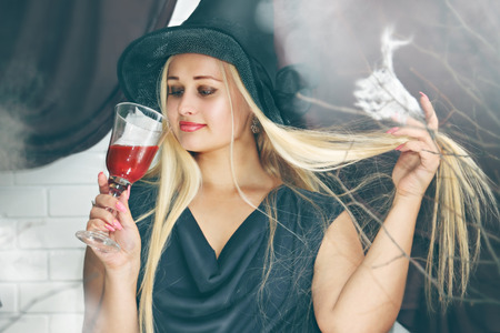 blonde witch with a big glass of bloodの写真素材