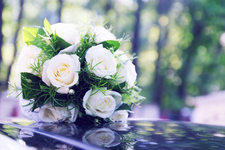 bridal bouquet of white roses lying on the carの写真素材
