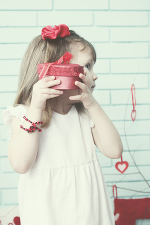 Girl holding a box near the earの写真素材