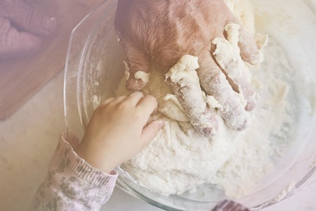 Grandfather and granddaughter preparing dumplings together, photo toning Pastel