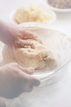 male hand knead the dough into dumplings, close up. photo toning Pastel