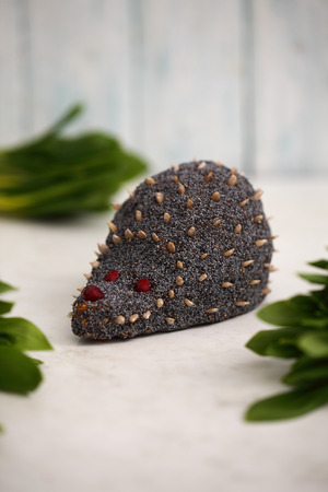 Cake in the shape of a hedgehog with poppy seeds and sunflower seeds. Food art creative concepts.