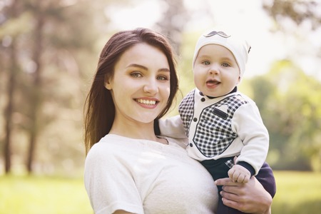 Happy woman and child in the blooming spring garden.Child kissing woman. Mothers day holiday conceptの写真素材