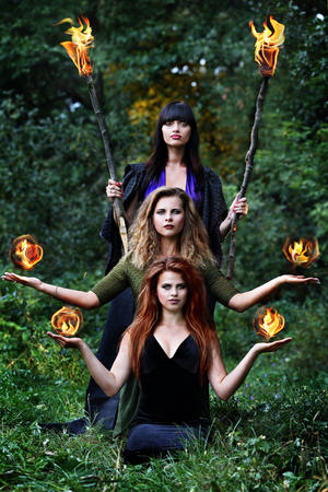 three witches are holding balls of fireの写真素材