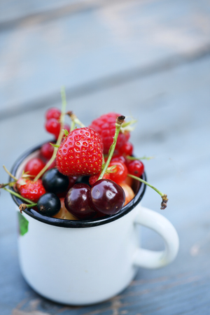 garden organic berries and fruits in a cupの写真素材