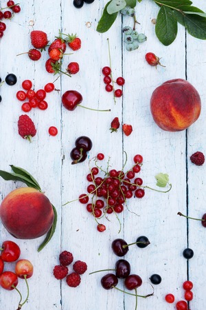 garden organic berries and fruits on white wooden backgroundの写真素材