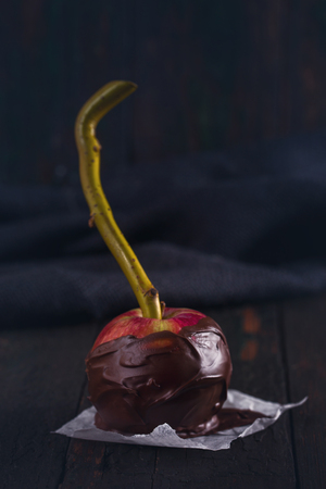 One red apple in black chocolateの写真素材
