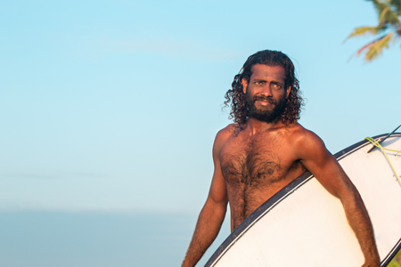 dark-skinned man with a surfboardの写真素材