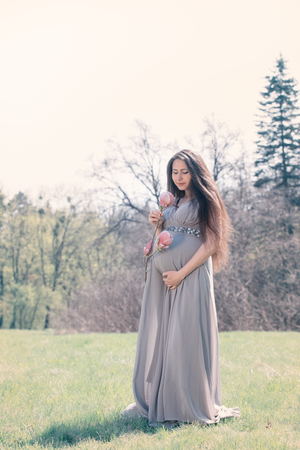 pregnant woman with a magnolia branchの写真素材