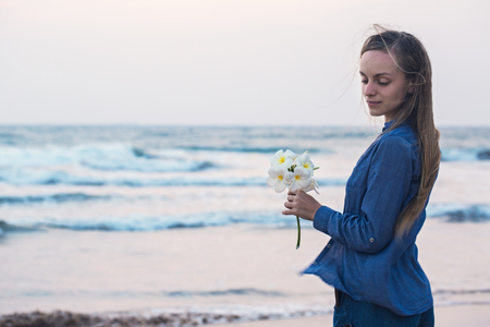 Girl with flower in the beachの写真素材