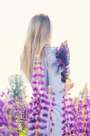 The girl with a bouquet of lupinesの写真素材