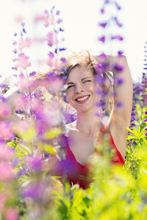 A woman looks out from behind the flowersの写真素材