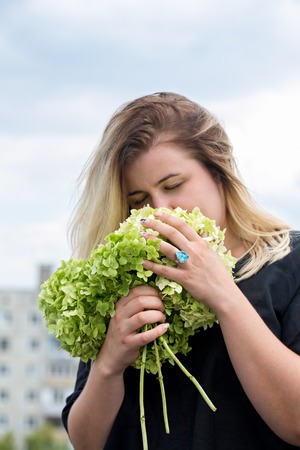 woman sniffing a bouquet of hydrangeasの写真素材