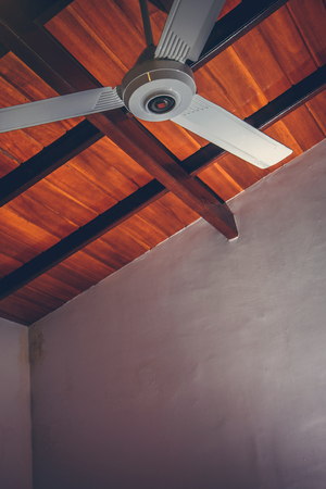 Ceiling fan on a wooden ceilingの写真素材