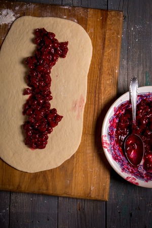 Dough with cherry filling on the boardの写真素材