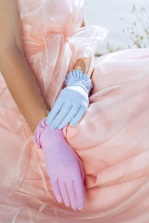 Beautiful designer multicolored gloves on a background of pink dressesの写真素材