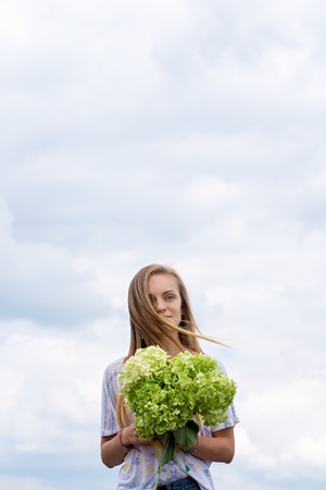 girl with a bouquet on the sky backgroundの写真素材
