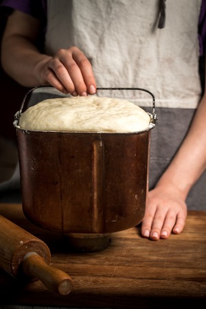 Female hand holds container with doughの写真素材