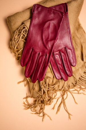 Stylish red leather gloves on a scarfの写真素材