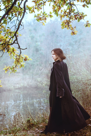 A girl over a cliff above the riverの写真素材