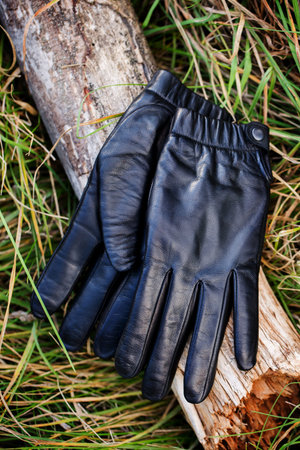 Vintage black women's gloves lie on a woodenの写真素材