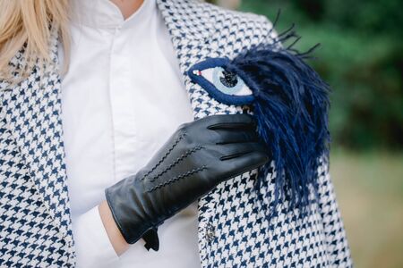 Girl in black classic gloves, eye shaped brooches and a goose foot coatの写真素材