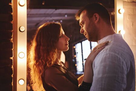 Touching young couple in hug at the mirrorの写真素材