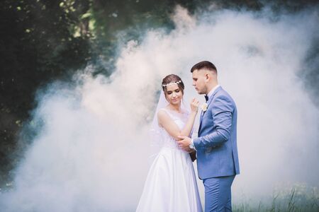 beautiful romantic couple in love amid white smokeの写真素材