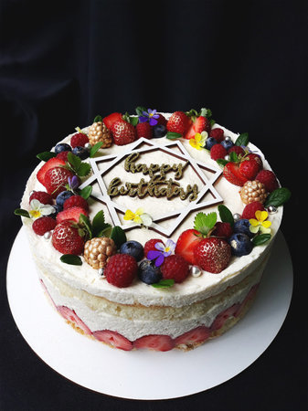 White cream cake with fruit and the inscription