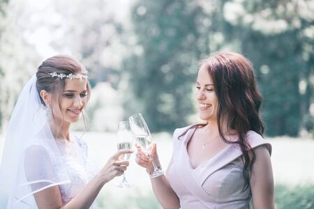 newlyweds with guests drink champagne in the parkの写真素材