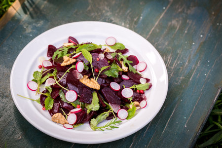 Salad of young beets, mustard leaves, radish nuts and garlic, in rustic style
