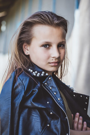 Beautiful brutal teen girl with pink hair and leather jacket in her hands