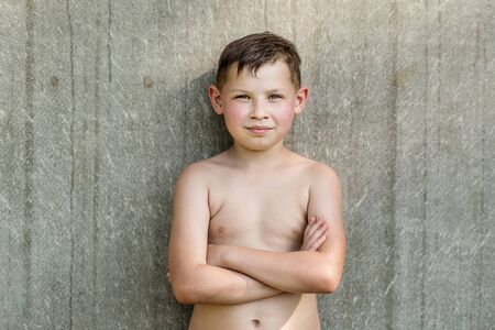 Summer portrait of a nine year old brutal boy on a gray backgroundの写真素材