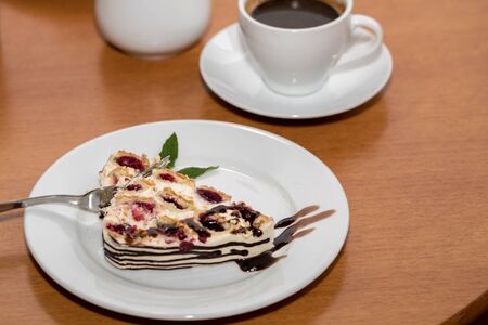 Cake with cherry on a plate and hot aromatic espresso in a cafeの写真素材