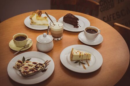 Various cakes and coffee on a table in a cafe, top viewの写真素材