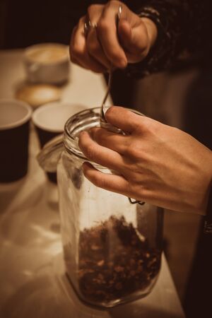 Woman takes tea from a glass jarの写真素材